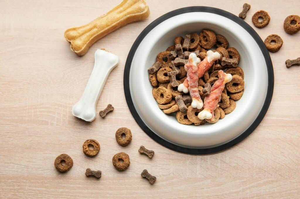A bowl of dog food on a wooden floor.